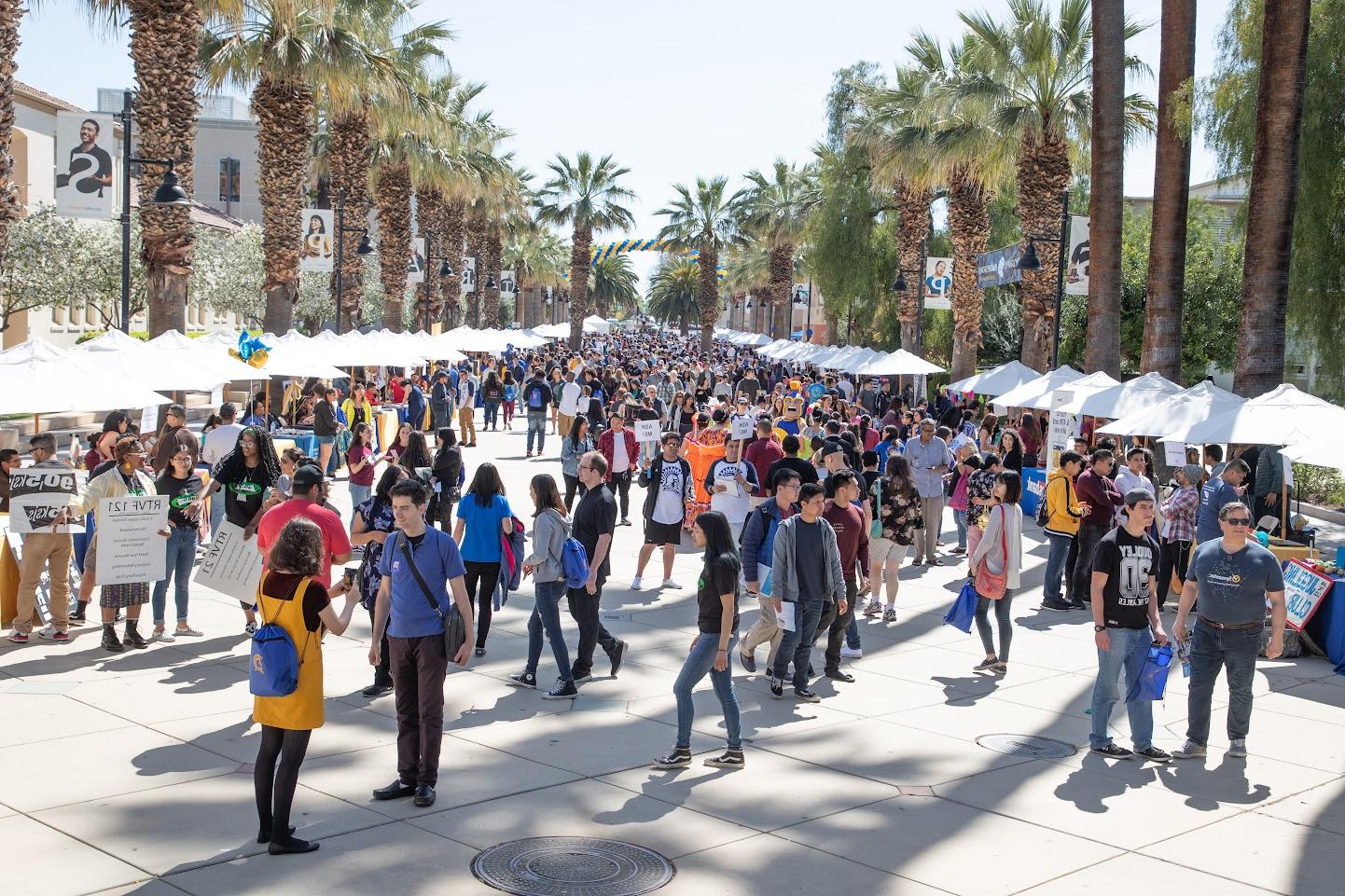 Hundreds of students walking around the Paseo during res我们的ce fair.