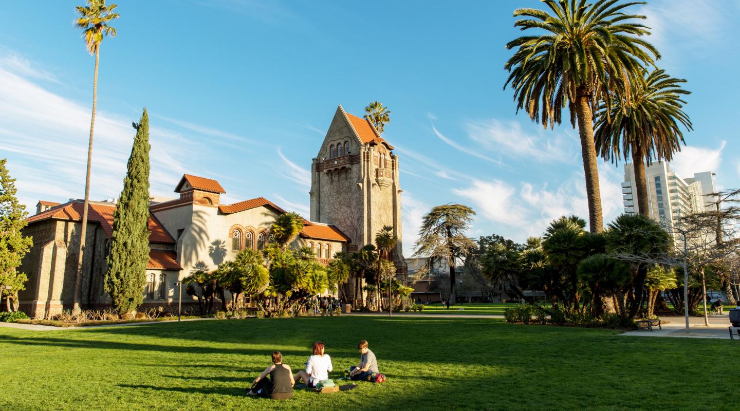 Students sitting on grass outside Tower Hall.